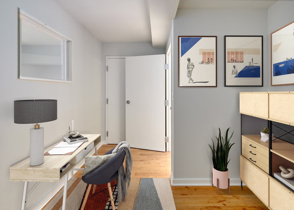 a living room with a desk and a chair and a door