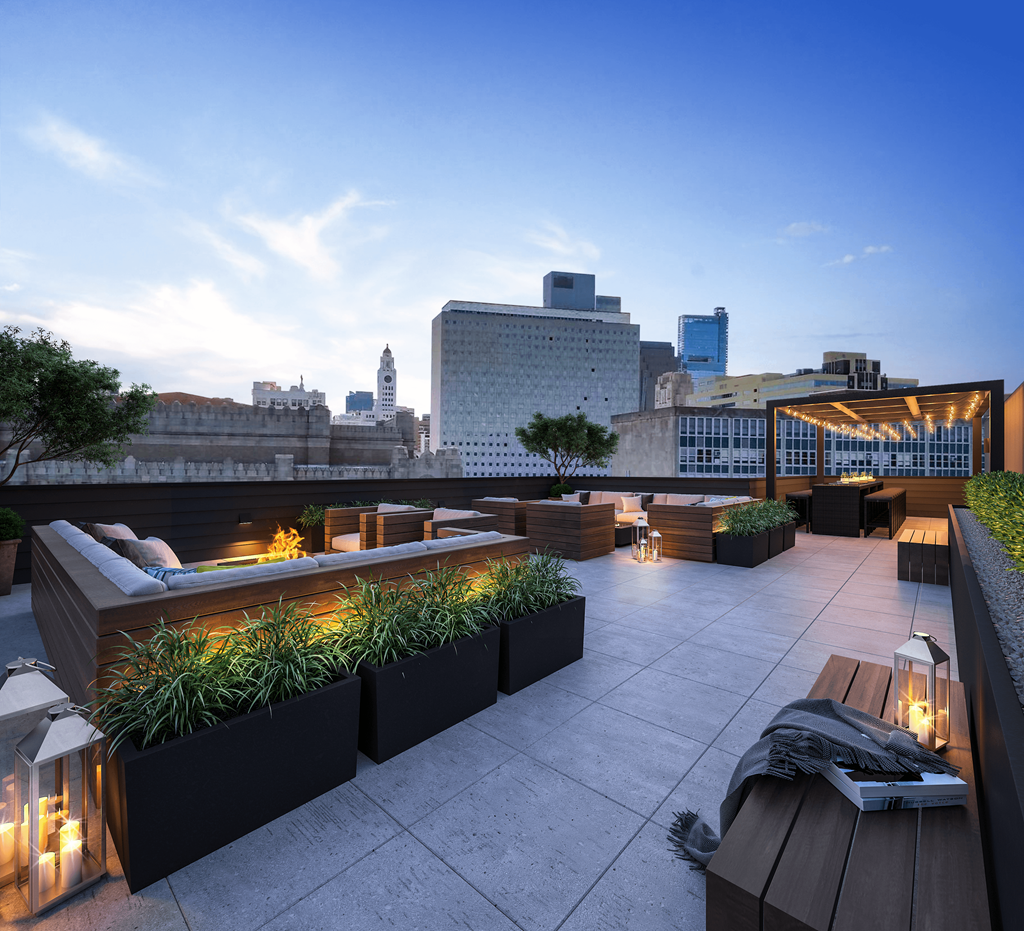 a rooftop terrace with seating and a city skyline in the background