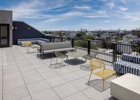 A balcony with a yellow chair and a white table. at The Weaver, Philadelphia, PA, 19125