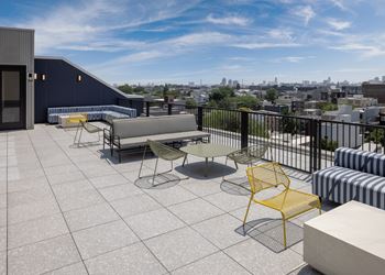 A balcony with a yellow chair and a white table. at The Weaver, Philadelphia, PA, 19125