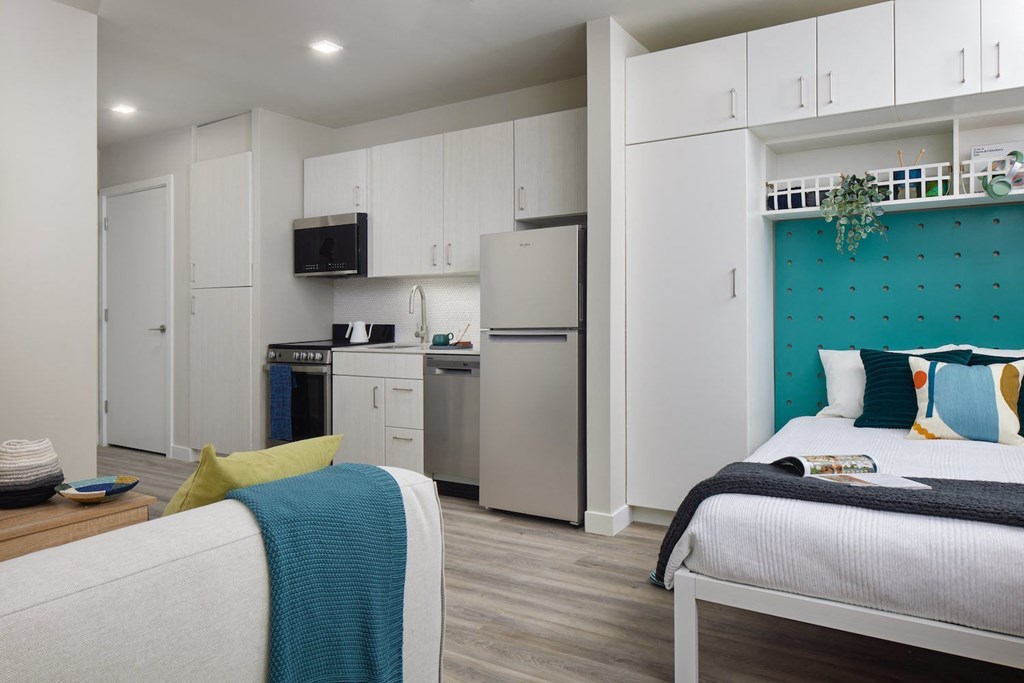 a bedroom with a bed and a refrigerator