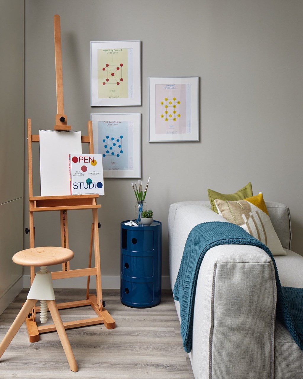 a bedroom with a bed and a easel with a painting on it