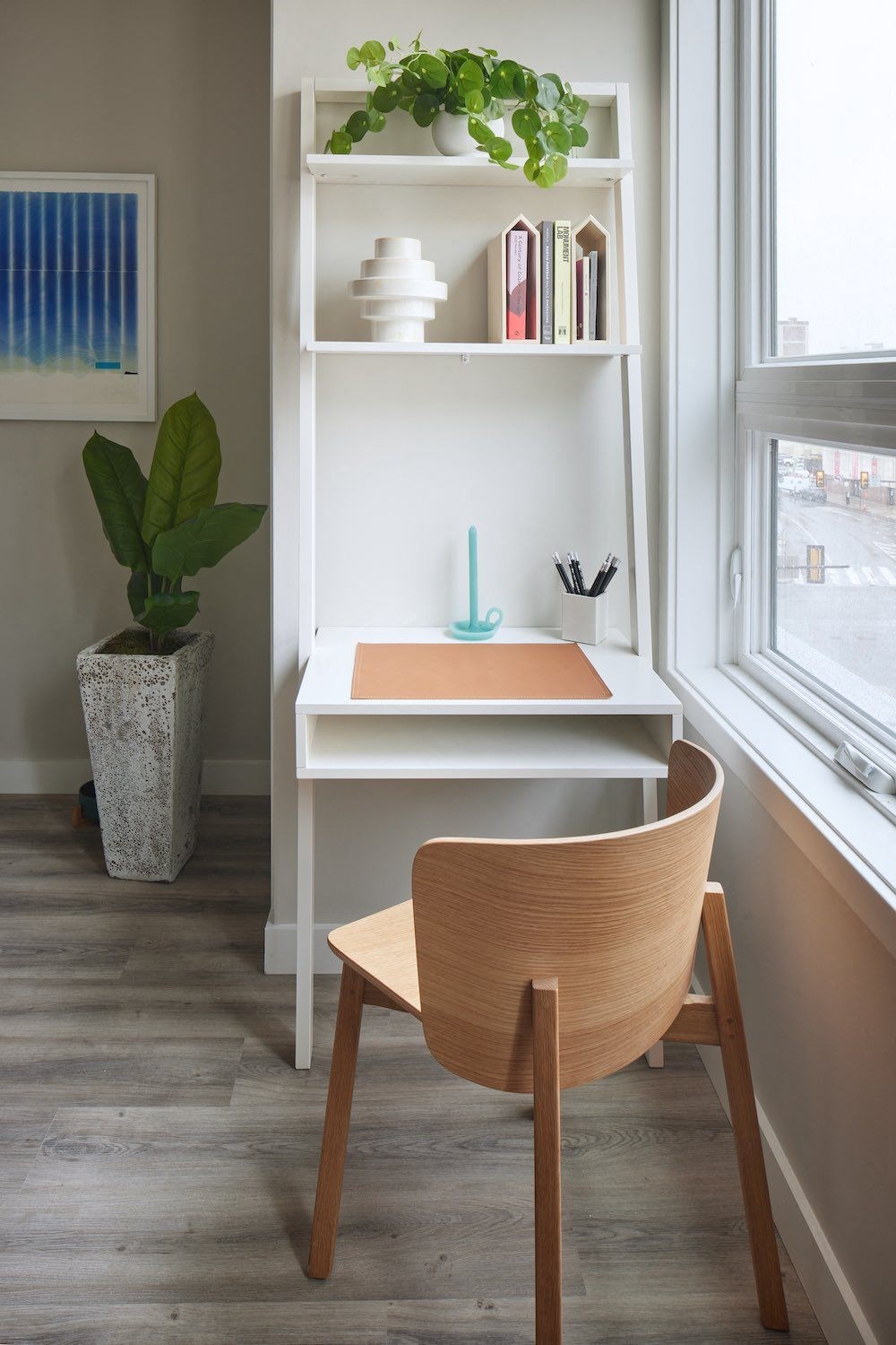 a wooden desk with a chair in front of a window