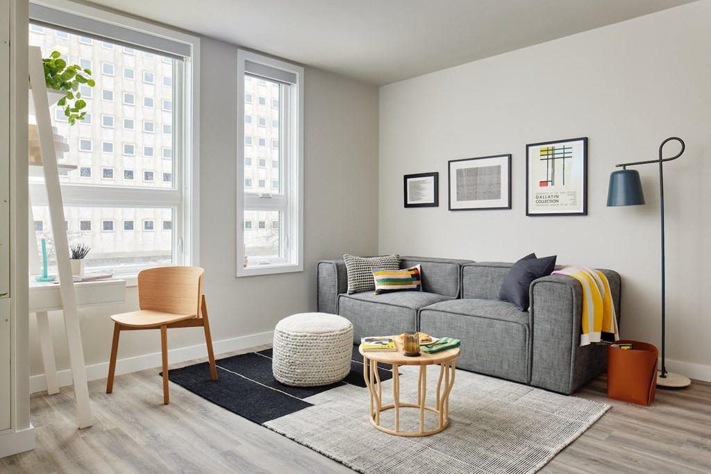 a living room with a couch and a chair and a window