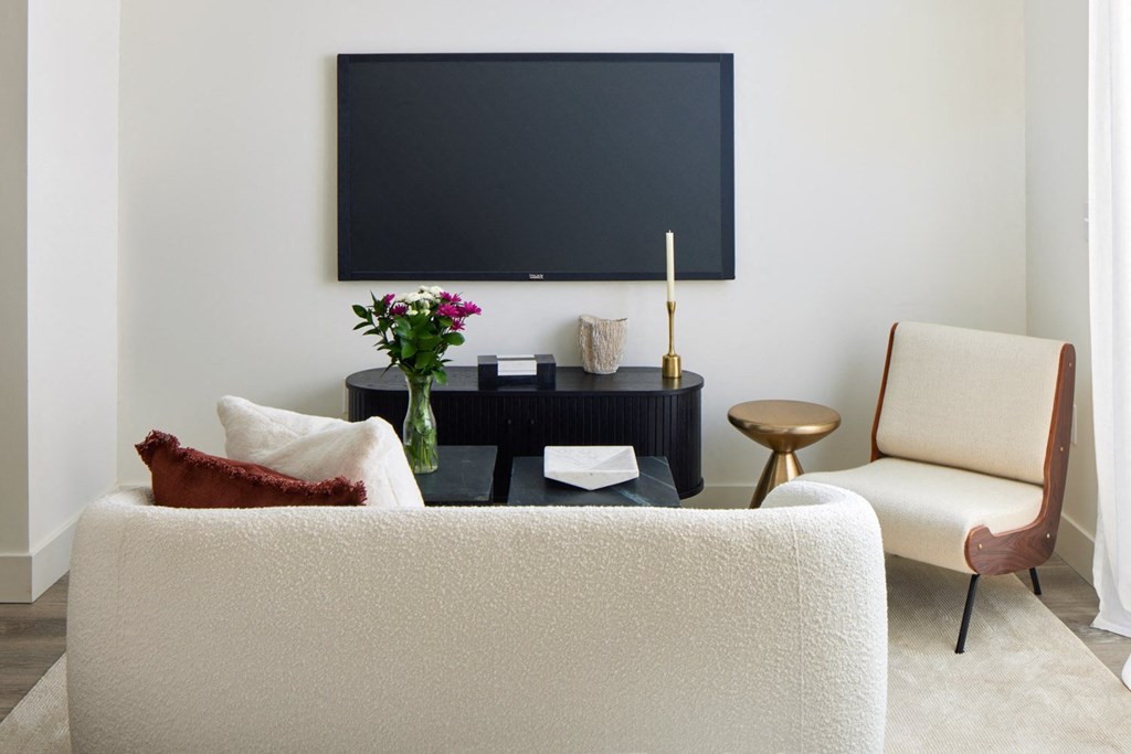 a living room with a white couch and a television