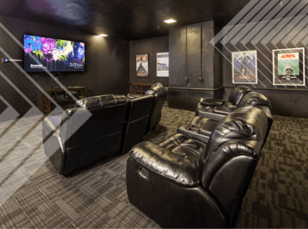 A black leather couch in a room with a television.