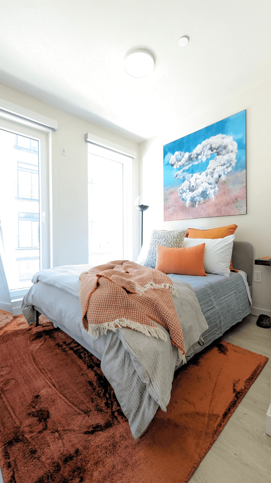 a bedroom with a bed and a painting on the wall