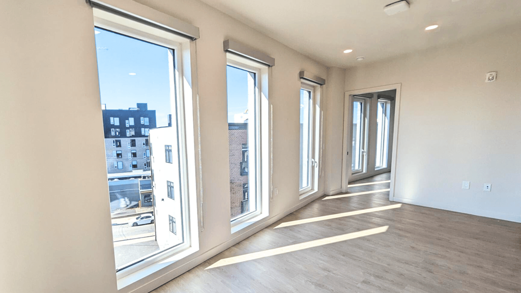 a living room with large windows and a wood floor