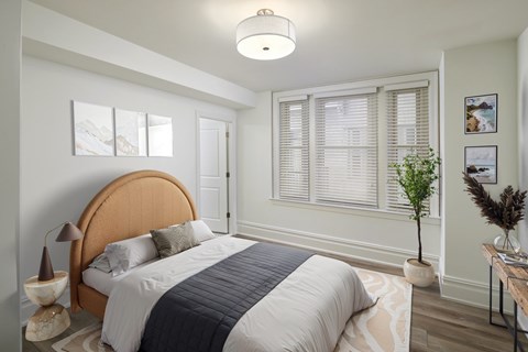 A bedroom with a large bed and a wooden headboard.