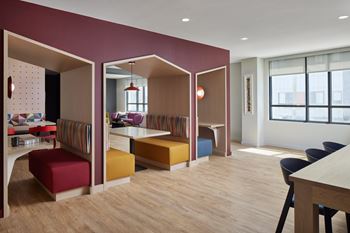a dining room and living room with colorful furniture and a table