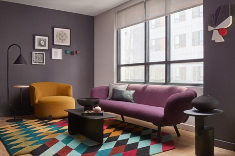 a living room with a purple couch and a yellow chair