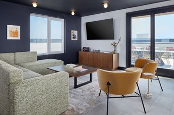 A living room with a grey couch, a yellow chair and a brown cabinet. at The Weaver, Philadelphia, PA, 19125
