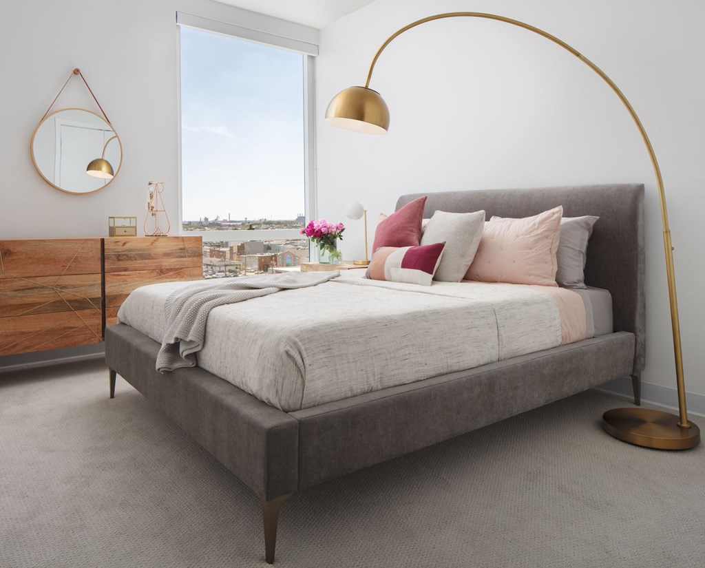 a bedroom with a large bed and a lamp