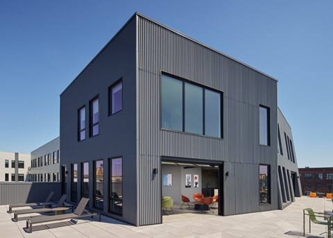 A modern building with a black exterior and large windows.