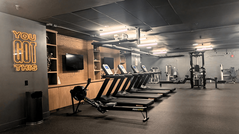 A gym with a row of rowing machines and a sign that says "You Got This".