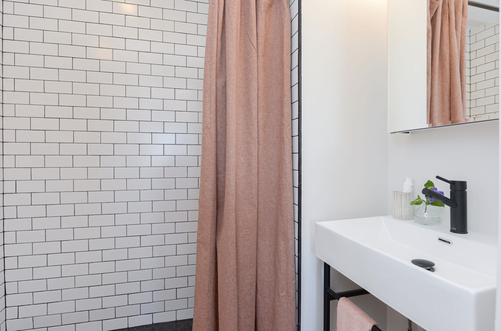a bathroom with a sink and shower and a shower curtain