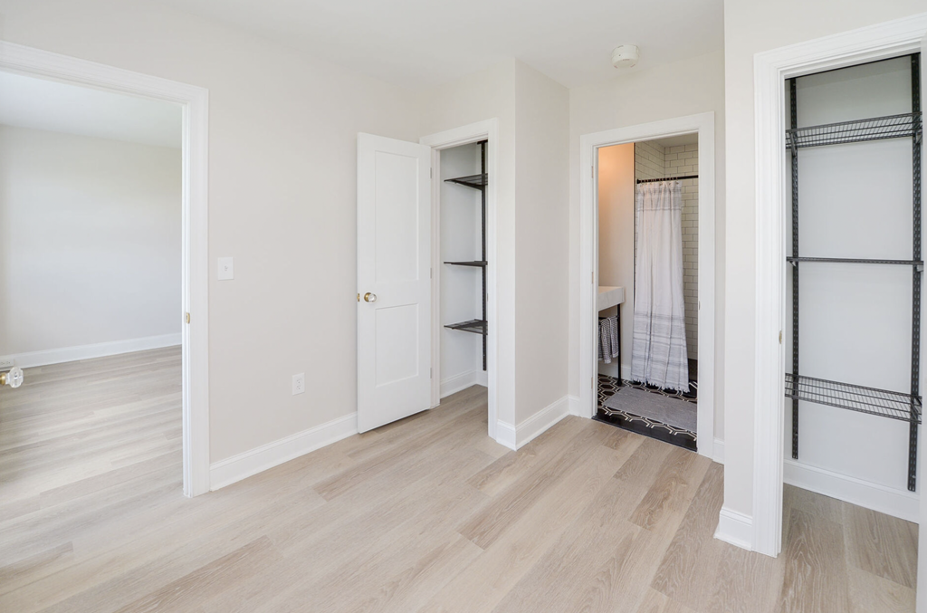 a renovated living room with white walls and wood floors