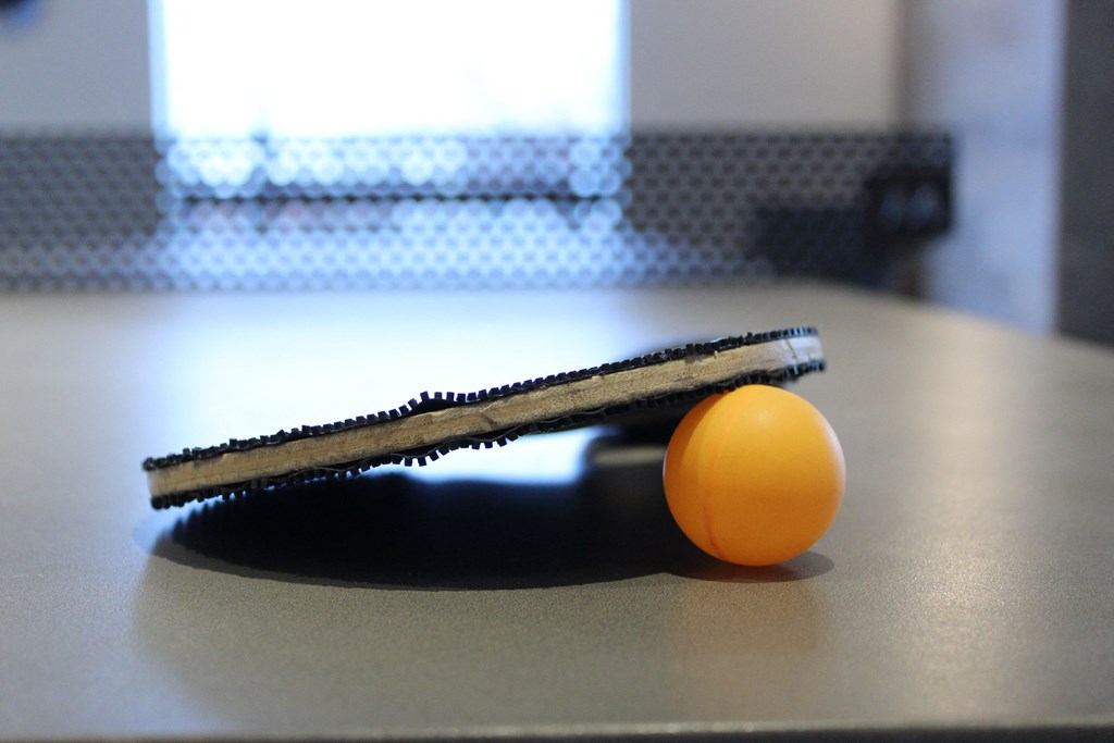 a tennis racket and an orange on a table