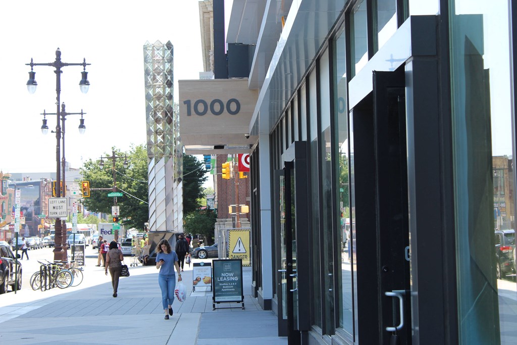 people walking down a sidewalk in front of a store