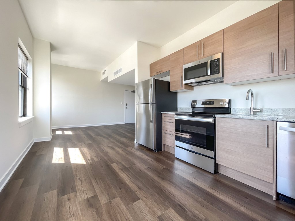 a kitchen with wood flooring and stainless steel appliances