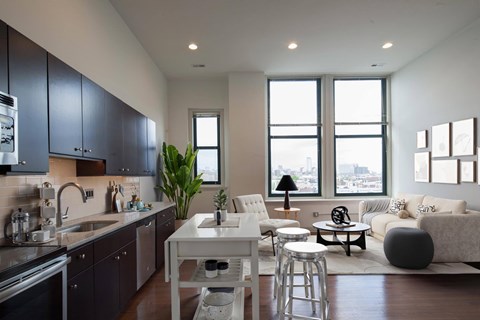 A modern kitchen with dark grey cabinets and a white island.