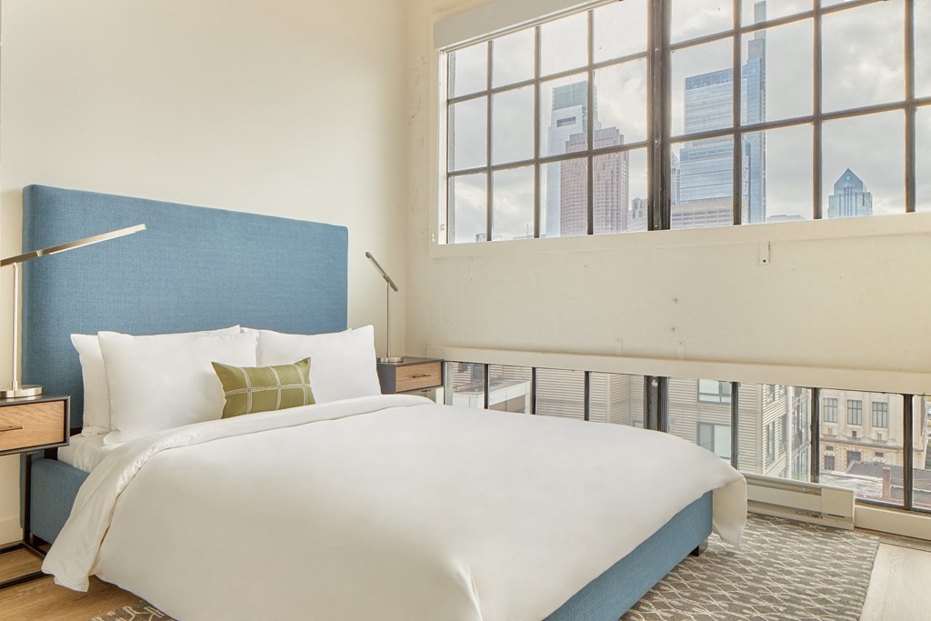 a bedroom with a large bed and a window