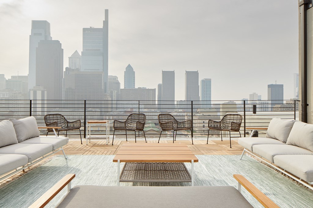 a rooftop patio with a view of a city skyline