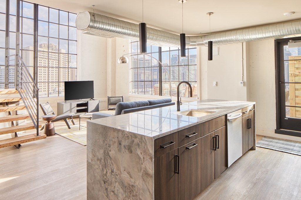 a kitchen with an island and a living room with a couch and a tv