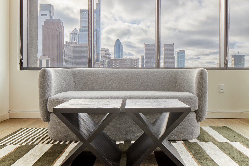 a living room with a couch and a table in front of a window