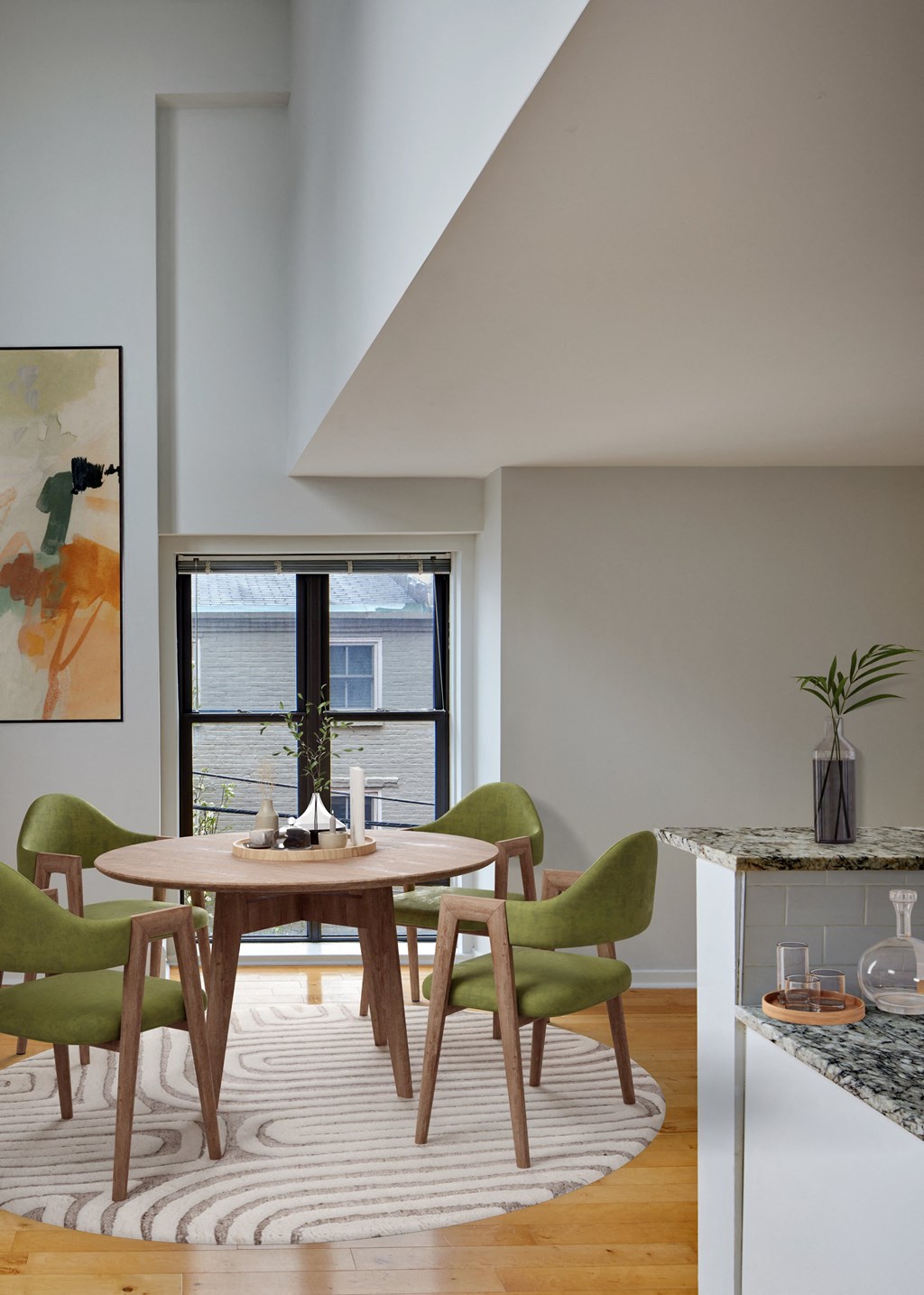 a dining room with a round wooden table and green chairs
