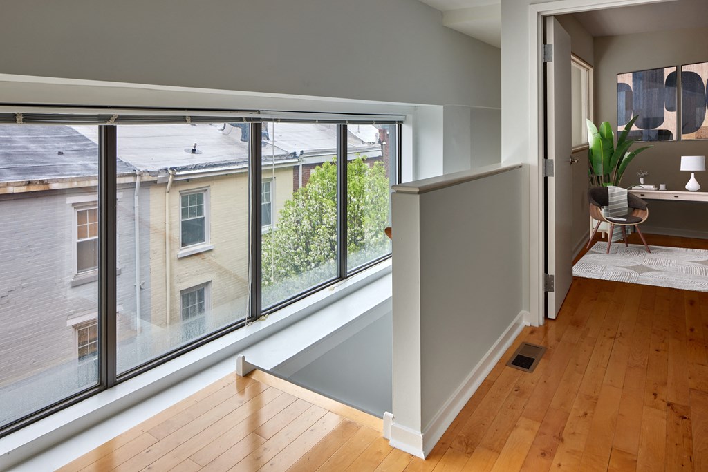 a living room with a large window and a wooden floor