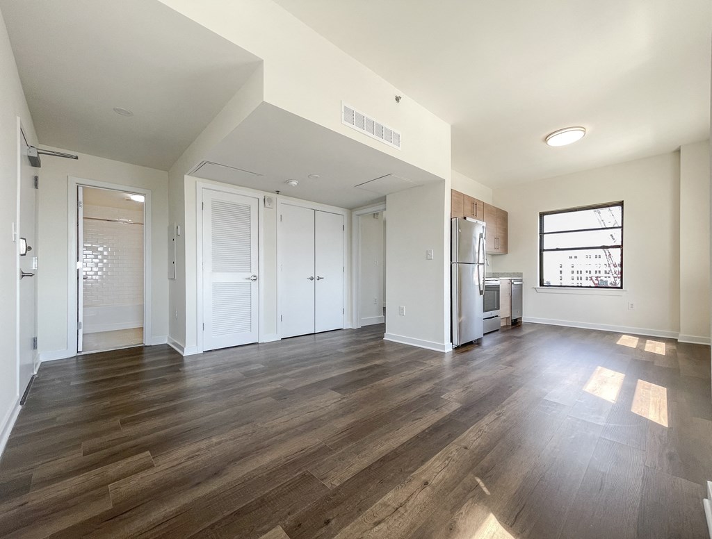 an empty living room with white walls and wood floors