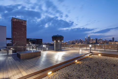 A rooftop with a wooden floor and a brick chimney.