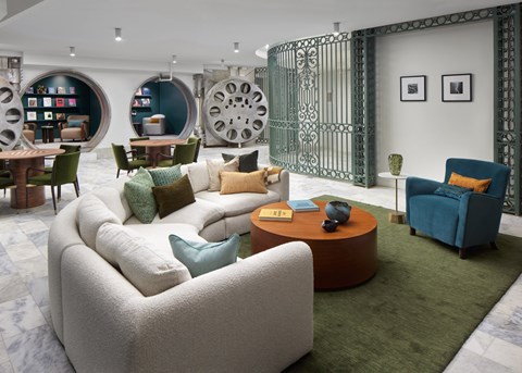 A living room with a white sofa and a green rug.