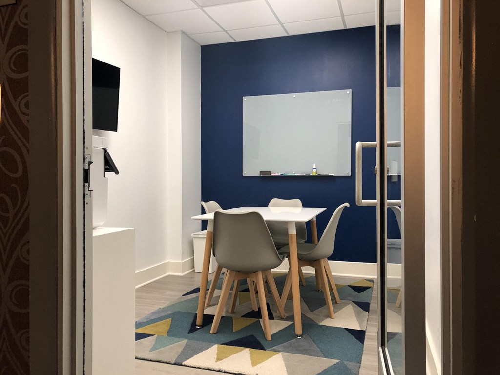 a table and chairs in a room with a blue wall