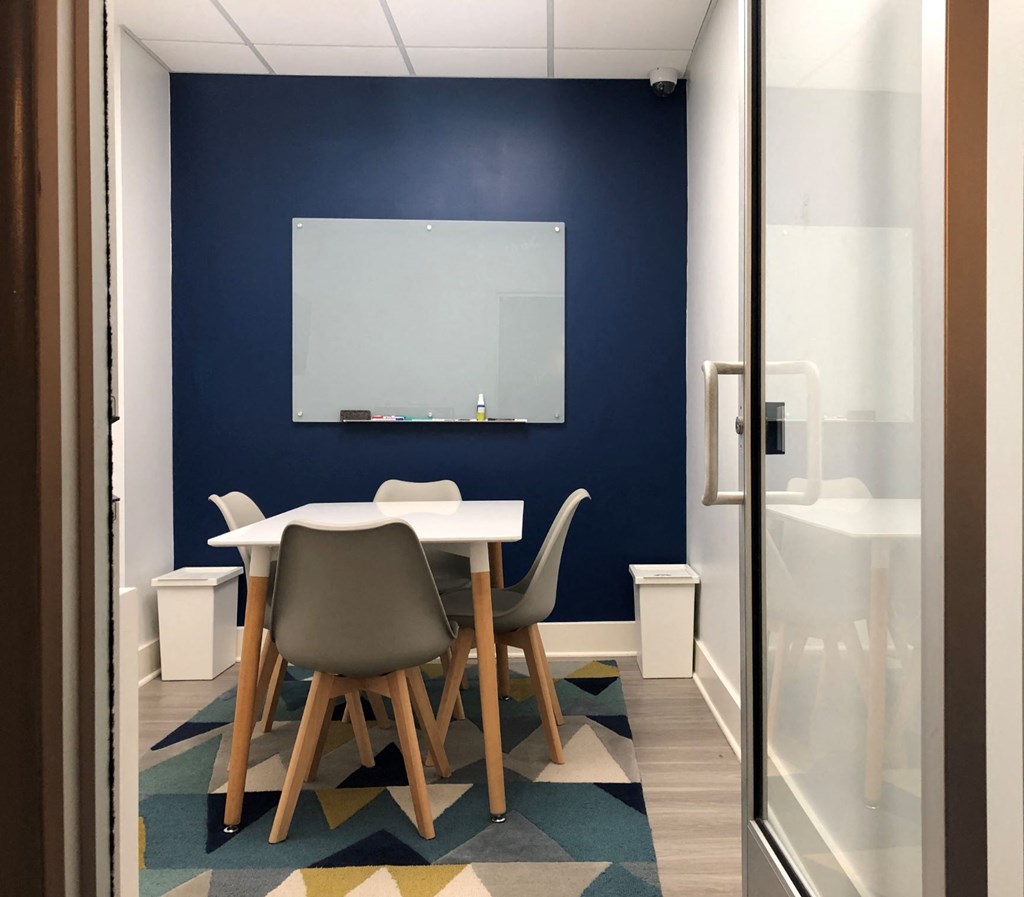 a table and chairs in a room with a blue wall