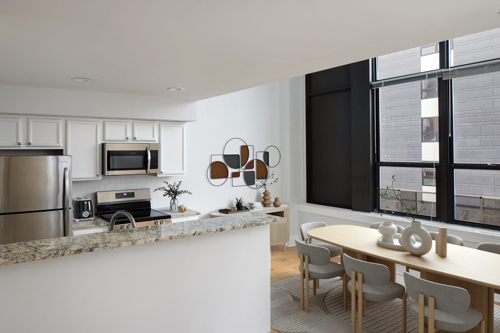a kitchen and dining area with a table and chairs and a refrigerator