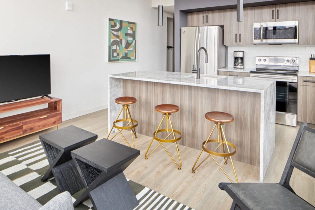 a kitchen and living room with a bar and stools