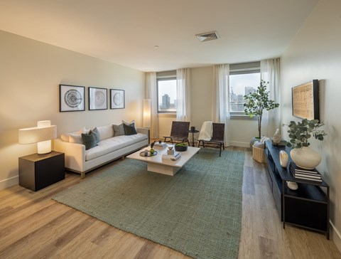 A living room with a couch, coffee table, and pictures on the wall.