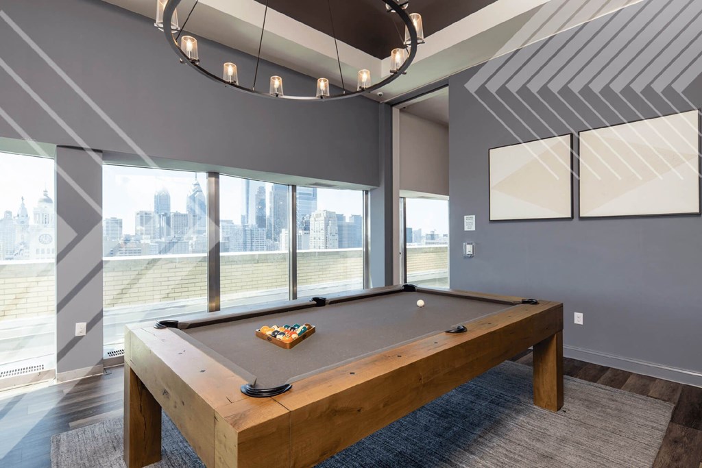 A pool table in a room with a view of the city.