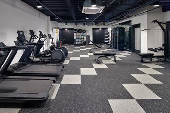 A gym with treadmills, weights, and a checkerboard floor. at The Weaver, Philadelphia, PA, 19125