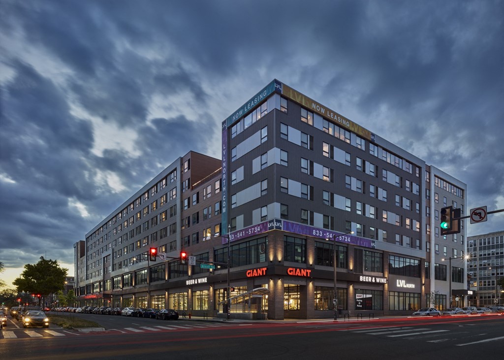 a rendering of a tall building on a city street at night