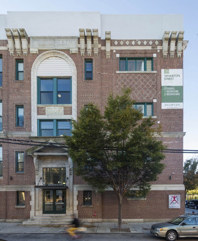 an old brick building with a tree in front of it