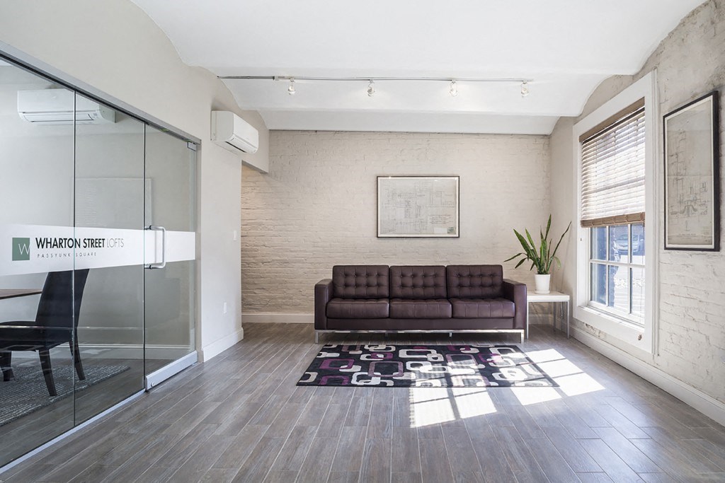 a living room with a couch and a rug and a glass door