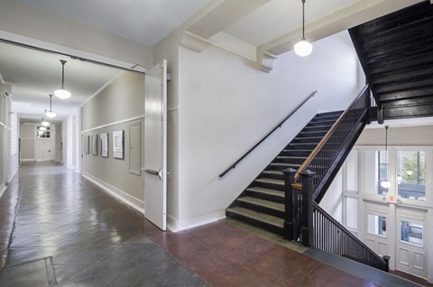 the lobby of a building with a staircase and a hallway withwindows and a staircase
