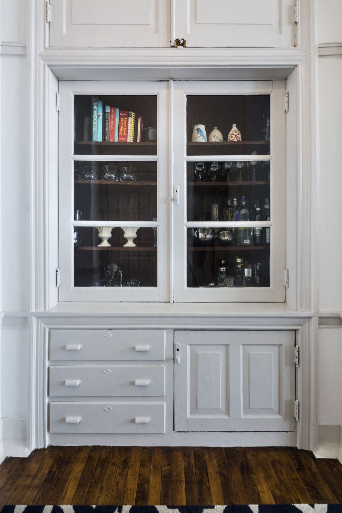 a kitchen with white cabinets and a window