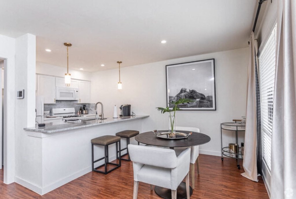 a living room and kitchen with a table and chairs