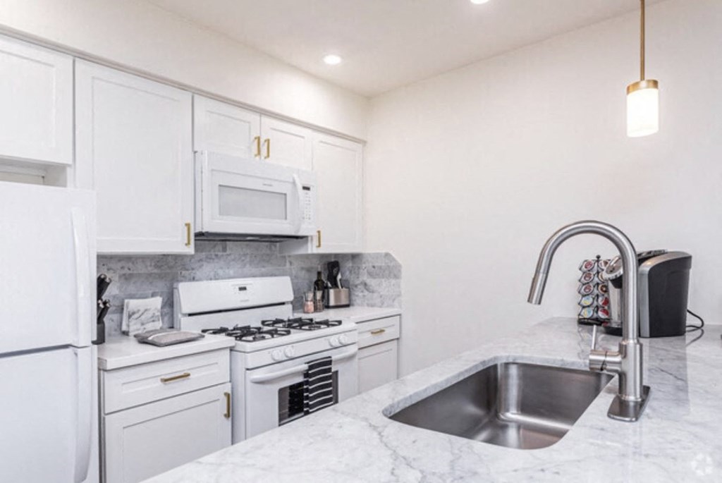 a kitchen with white cabinets and a sink