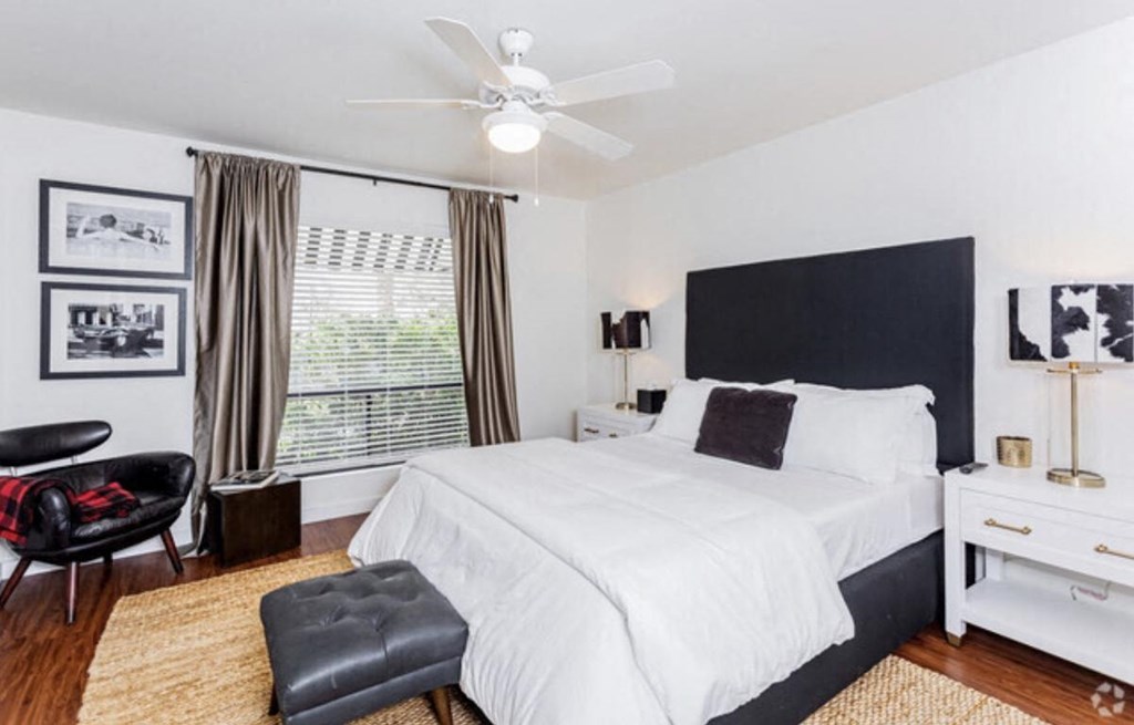 a bedroom with a large bed and a ceiling fan