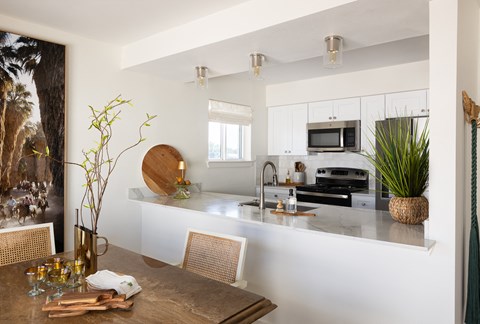 A modern kitchen with a wooden table and chairs.